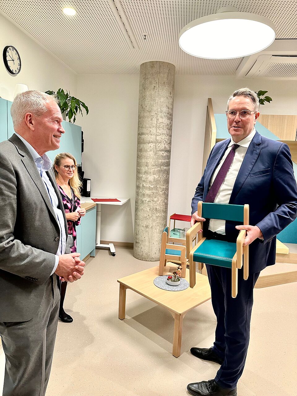 Herr Maser und Ministerpräsident Schweitzer, der Kindergartenstuhl hält